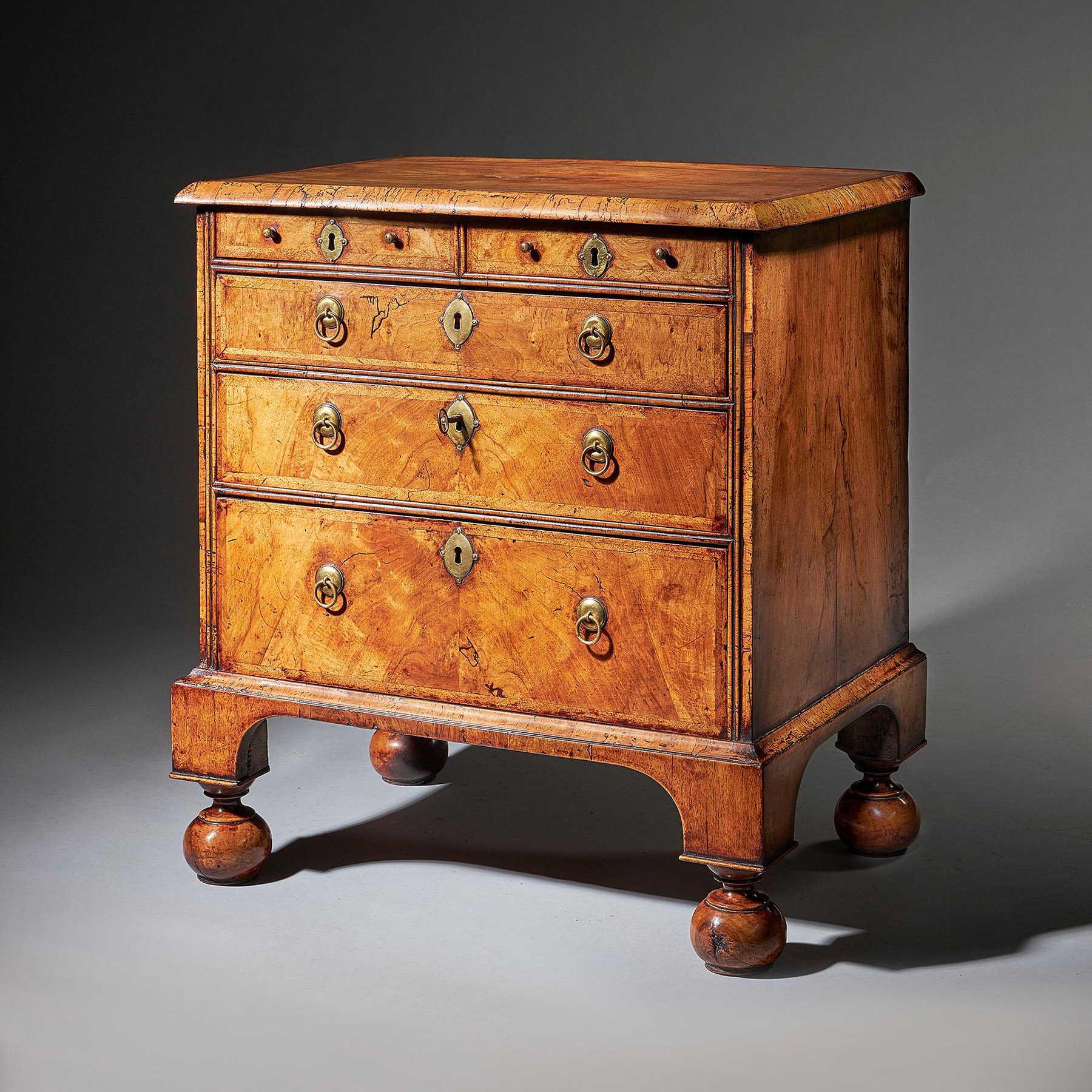 An extremely rare George I walnut chest of small proportions on ball and bracket 2