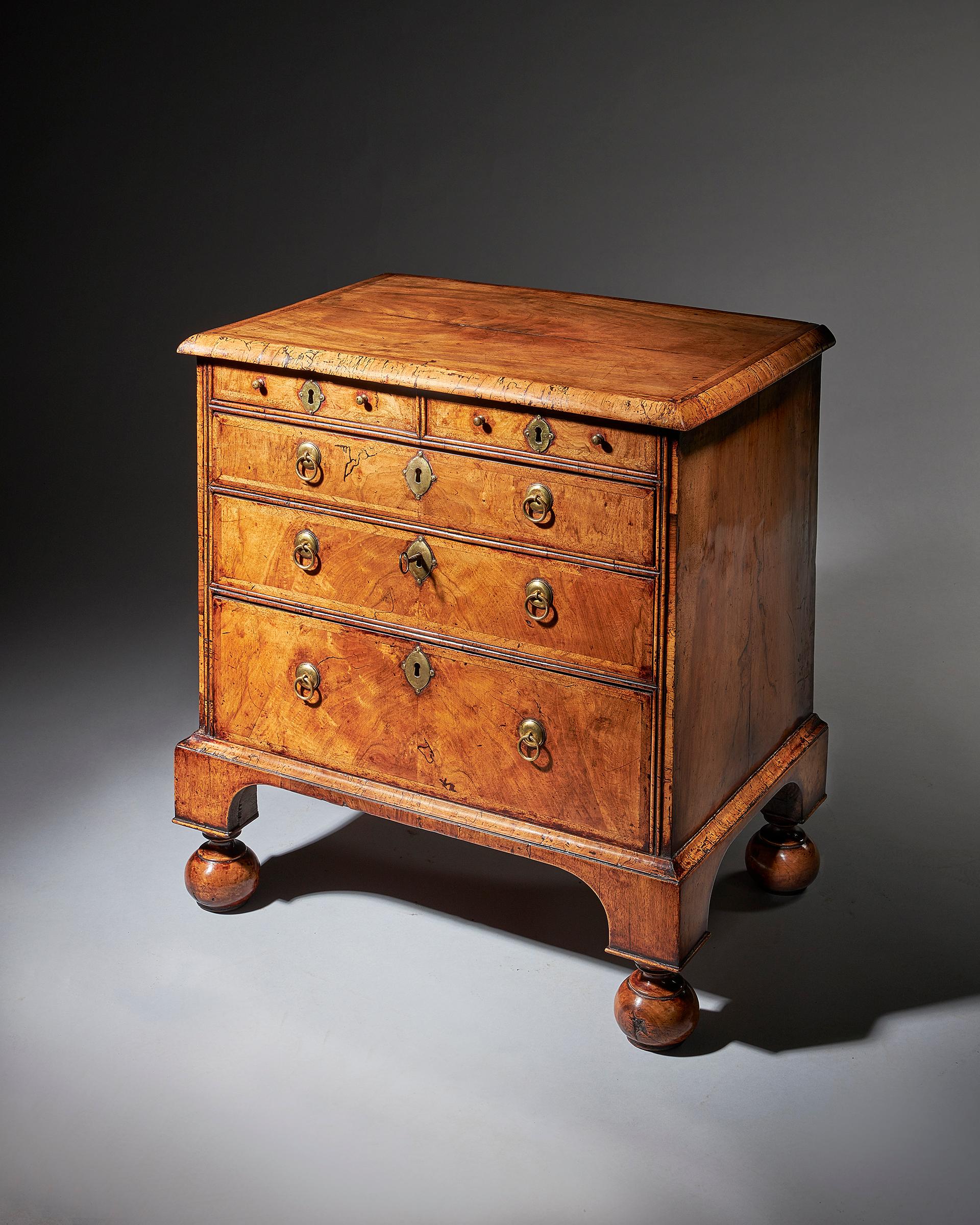 An extremely rare George I walnut chest of small proportions on ball and bracket 1