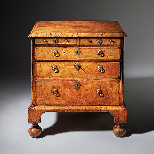 An extremely rare George I walnut chest of small proportions on ball and bracket