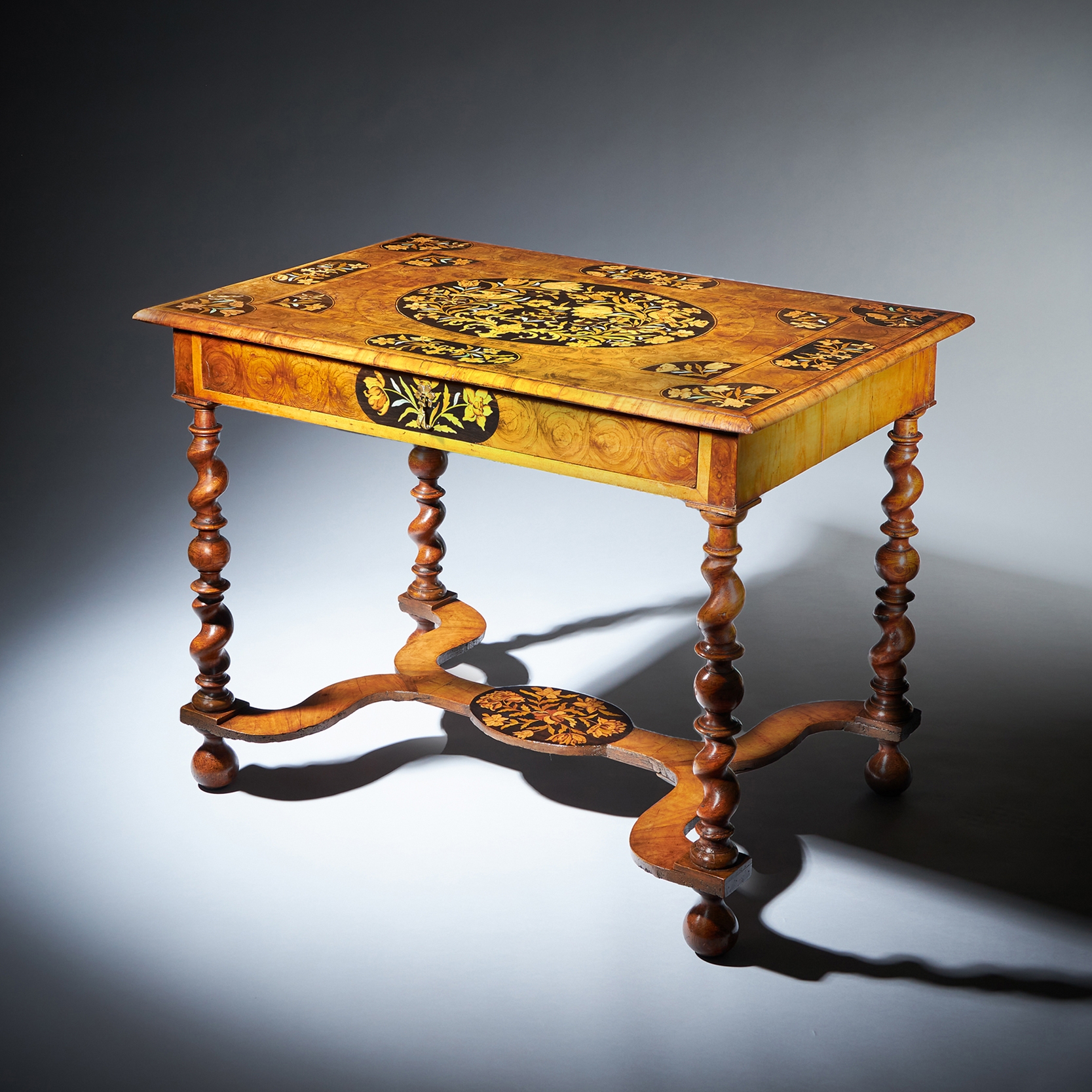 The important floral marquetry inlaid olive oyster and ebony table. 1